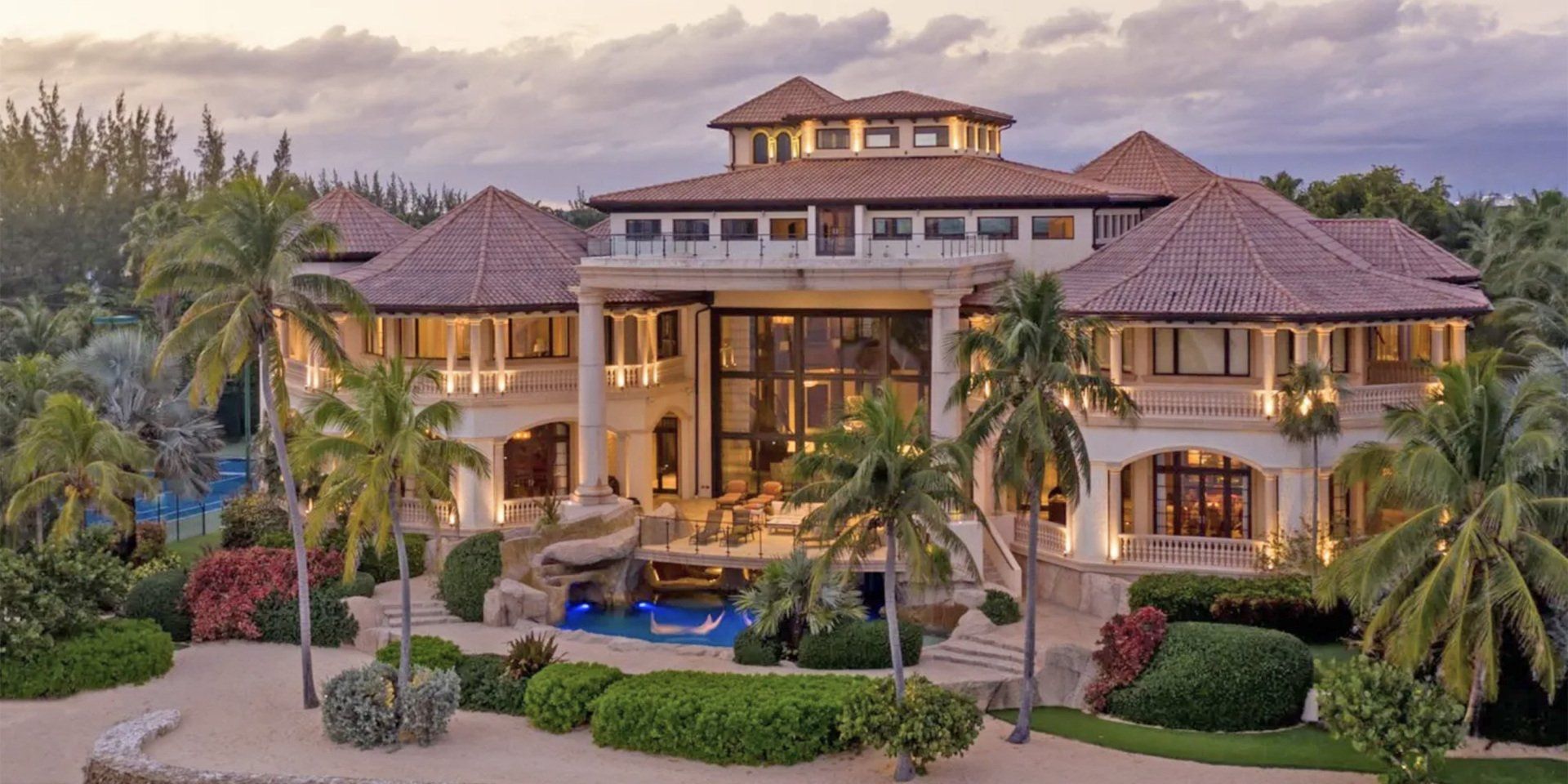 an aerial view of a large house surrounded by palm trees