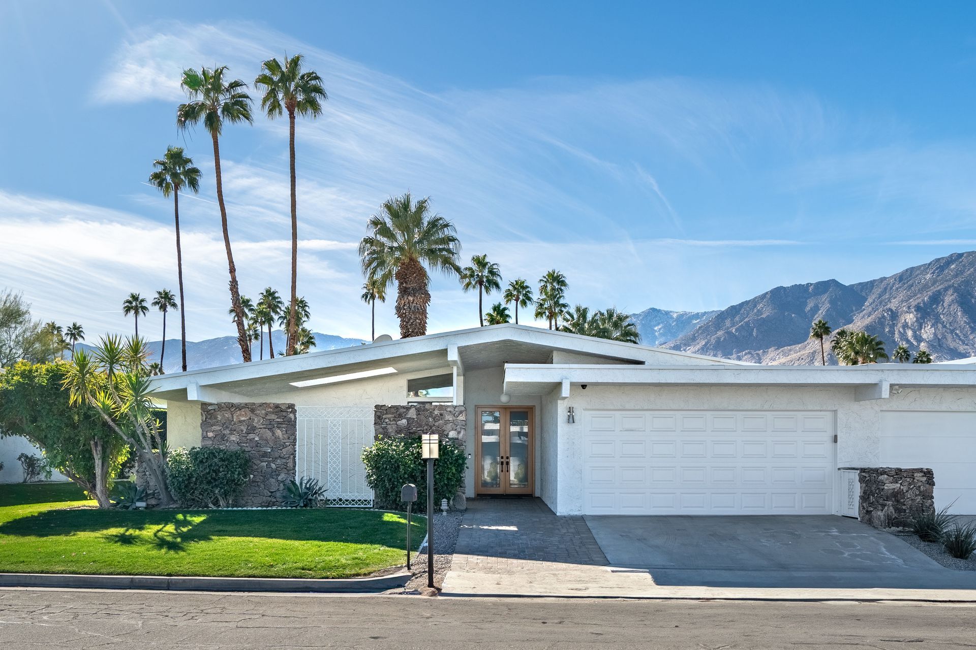 a white house with palm trees in front of it